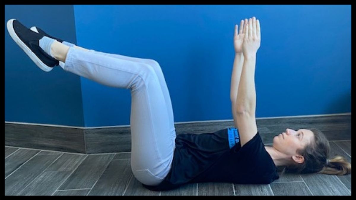 Lie down with arms up straight in the air, and legs as if in sitting position