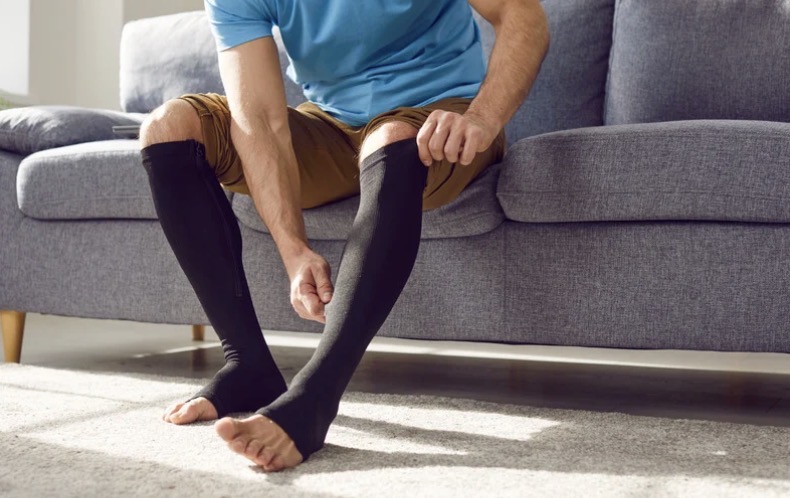 Man putting on compression socks.
