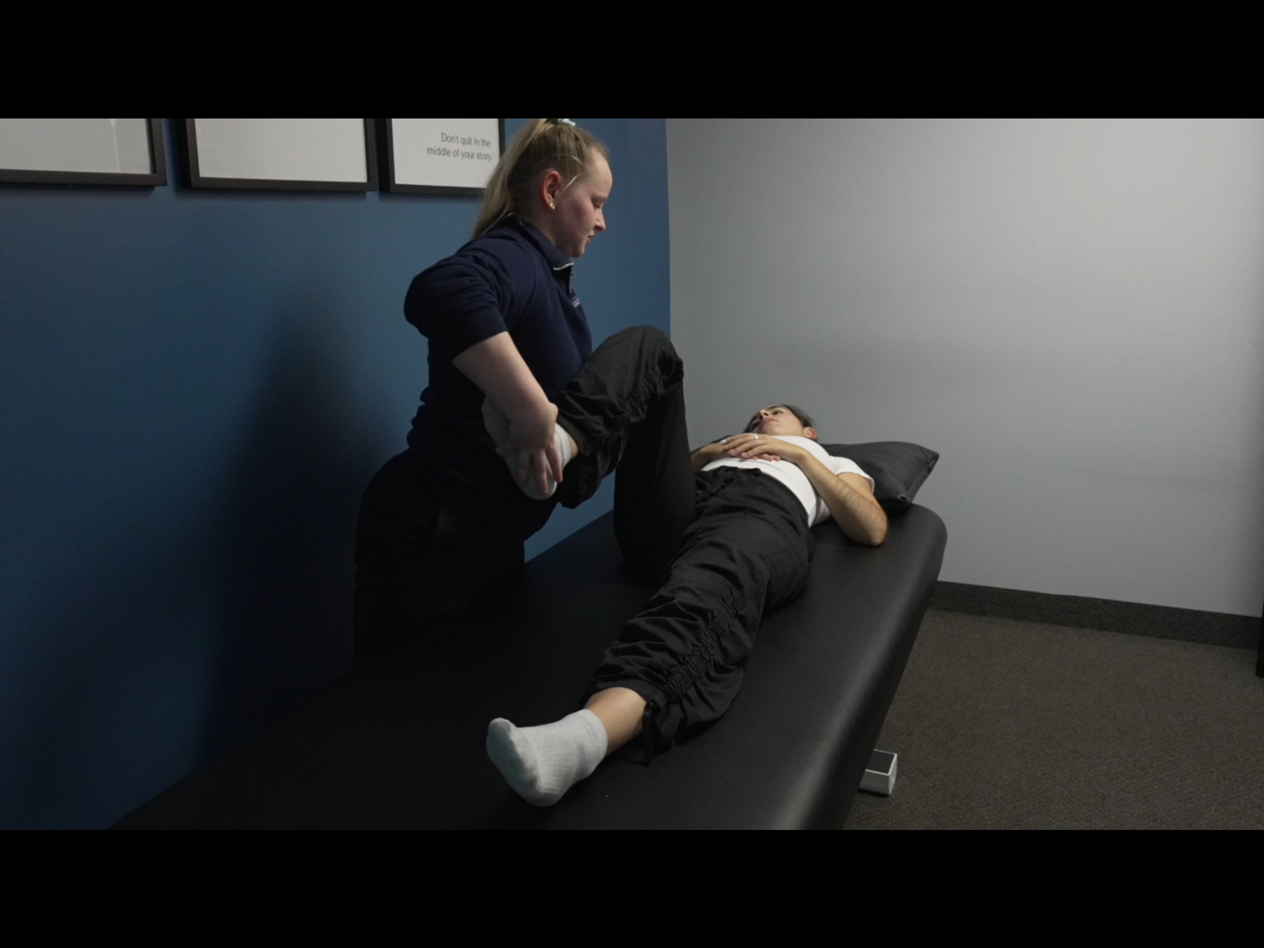 An osteopath performing hip testing on a patient.